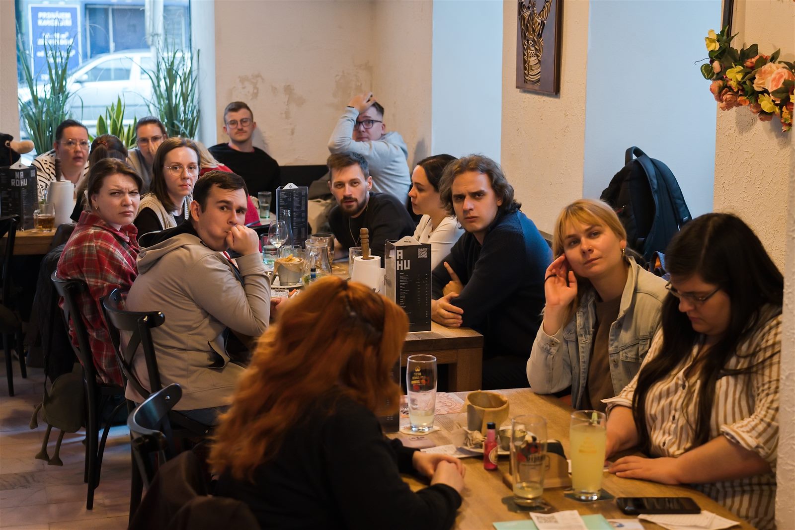 Tím hráčov premýšľa nad otázkou pri stole v podniku